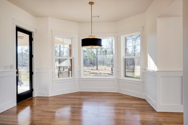 unfurnished dining area with plenty of natural light and wood-type flooring