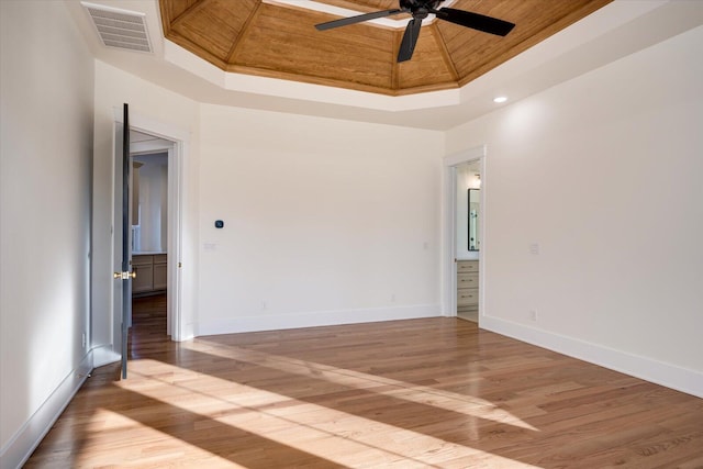 unfurnished room with a raised ceiling, ceiling fan, wooden ceiling, and ornamental molding