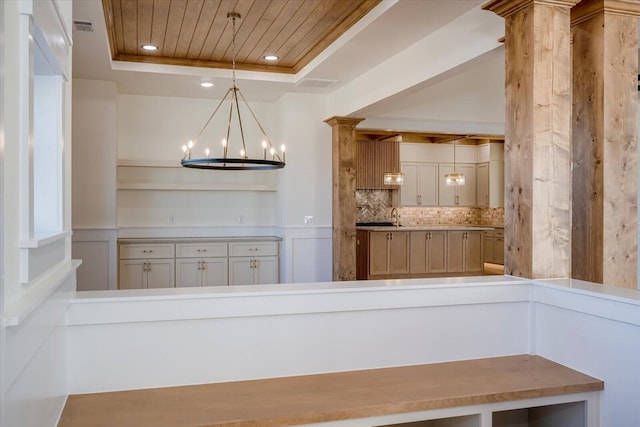 interior space with hanging light fixtures, backsplash, decorative columns, a tray ceiling, and wood ceiling