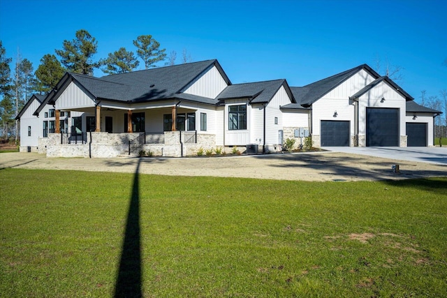 modern farmhouse with a garage, covered porch, and a front yard
