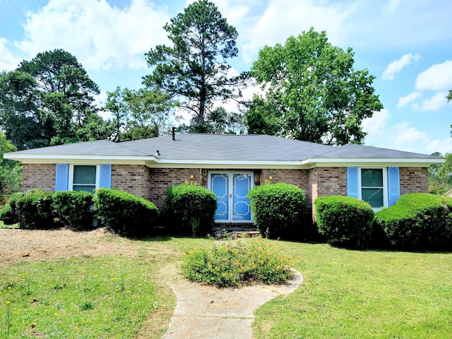 ranch-style house with a front lawn and brick siding