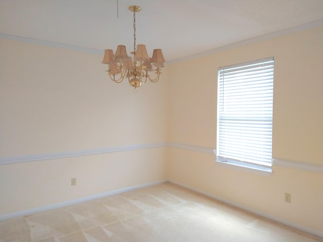 spare room with a chandelier, crown molding, baseboards, and light colored carpet