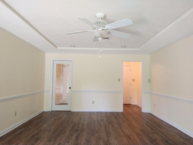 spare room featuring wood finished floors, a tray ceiling, a ceiling fan, baseboards, and a textured ceiling