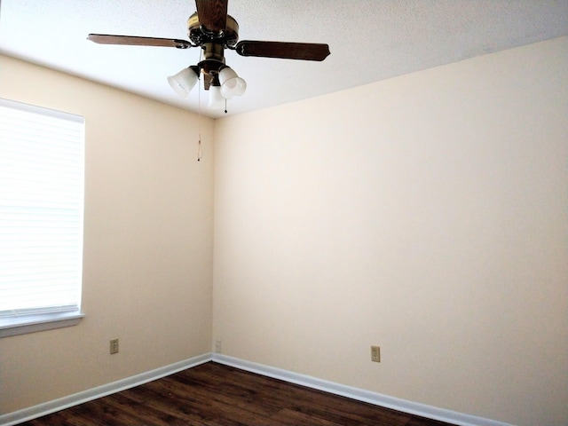 empty room with dark wood-style flooring, baseboards, and ceiling fan