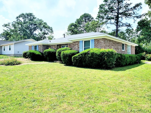 single story home with brick siding and a front yard