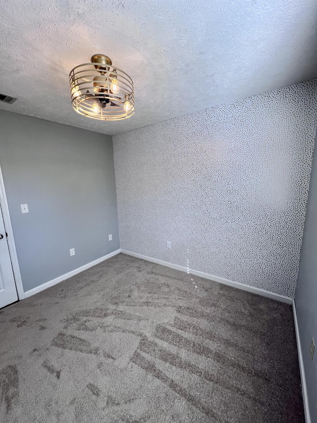 unfurnished room with baseboards, a textured ceiling, and carpet