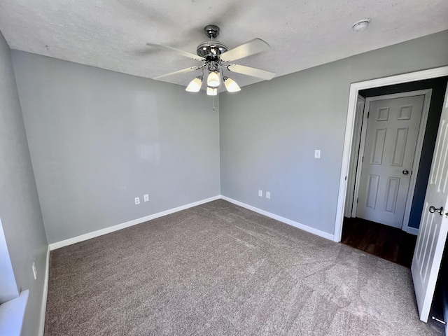 carpeted spare room with a ceiling fan, baseboards, a textured ceiling, and a smoke detector