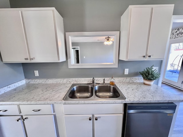 kitchen with stainless steel dishwasher, a sink, white cabinets, a ceiling fan, and light countertops