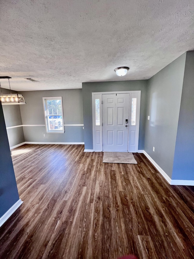 entryway with a textured ceiling, baseboards, dark wood-style floors, and healthy amount of natural light