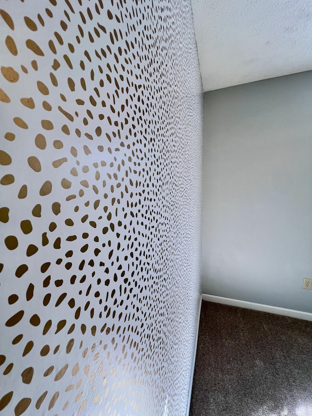 detailed view of carpet floors, a textured ceiling, and baseboards