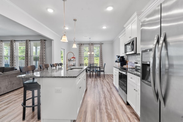 120 Dublin Loop, Grovetown, GA 30813 - kitchen with appliances with stainless steel finishes, a breakfast bar, light wood finished floors, a kitchen island with sink, and recessed lighting