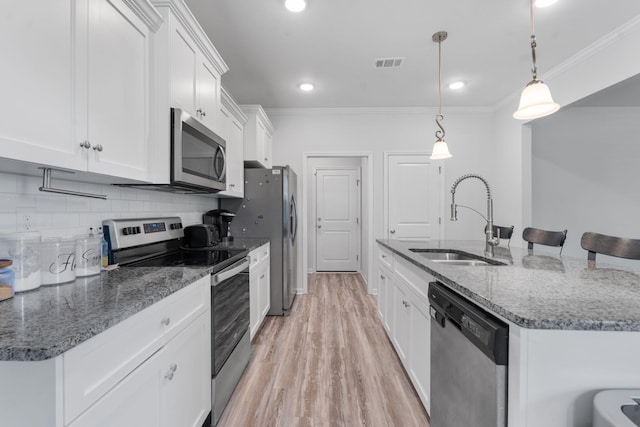 120 Dublin Loop, Grovetown, GA 30813 - kitchen with stainless steel appliances, ornamental molding, white cabinetry, a kitchen island with sink, and light wood-style flooring