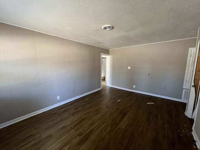 spare room with dark hardwood / wood-style floors and a textured ceiling