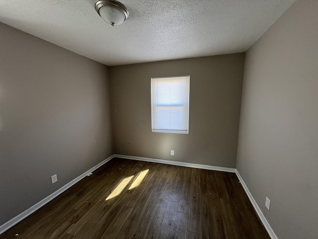 unfurnished room featuring dark hardwood / wood-style floors and a textured ceiling