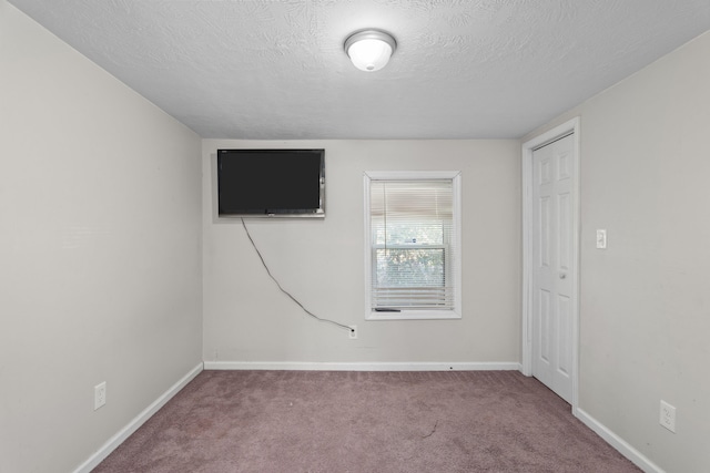 carpeted spare room featuring a textured ceiling