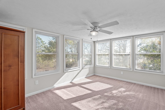 unfurnished sunroom with ceiling fan and plenty of natural light