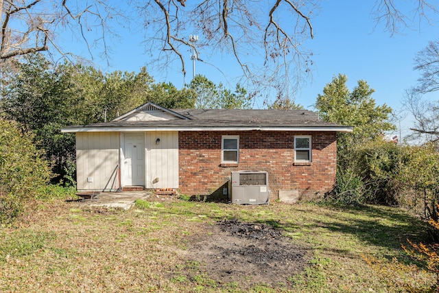 back of property with cooling unit and a yard