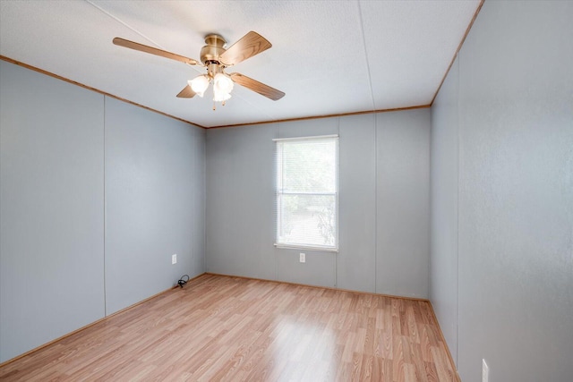 empty room with a textured ceiling, light hardwood / wood-style floors, ceiling fan, and crown molding