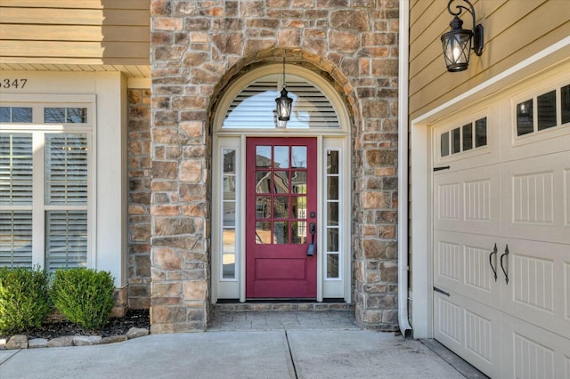 property entrance featuring a garage, stone siding, and brick siding