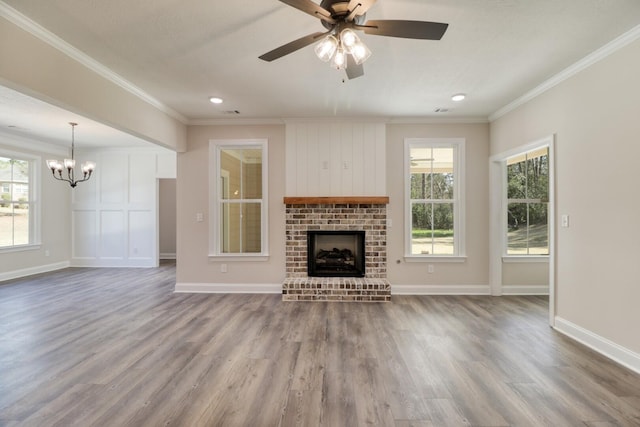 unfurnished living room featuring baseboards, a brick fireplace, wood finished floors, and crown molding