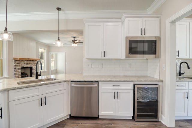 kitchen with a sink, built in microwave, stainless steel dishwasher, and beverage cooler