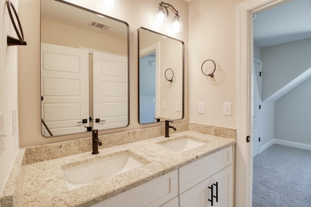 bathroom with a sink, visible vents, baseboards, and double vanity