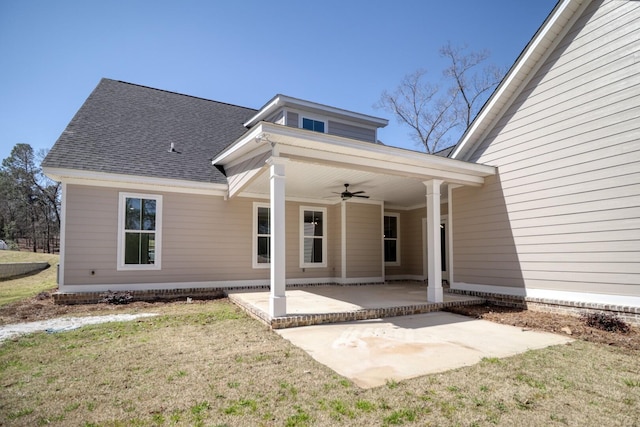 back of house with a shingled roof, a patio, a yard, and ceiling fan