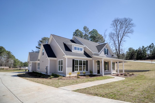 view of front of property with a front yard, a porch, driveway, and roof with shingles