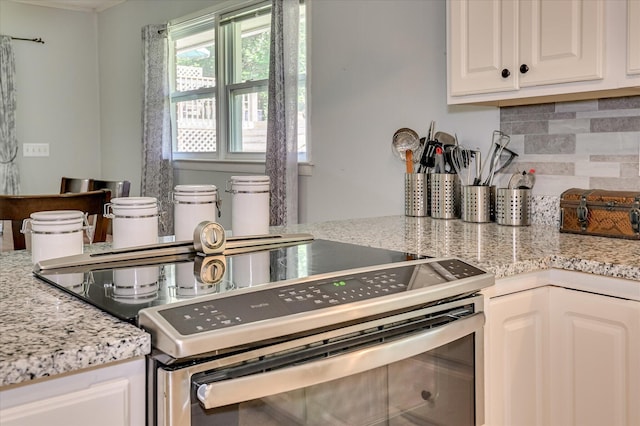 3114 Sussex Rd, Augusta, GA 30909 - kitchen with stainless steel electric stove, tasteful backsplash, white cabinets, and light stone countertops