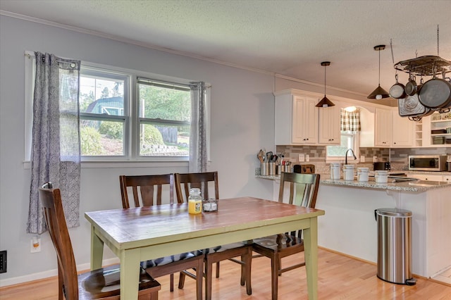 3114 Sussex Rd, Augusta, GA 30909 - dining space featuring light wood finished floors, a textured ceiling, and ornamental molding
