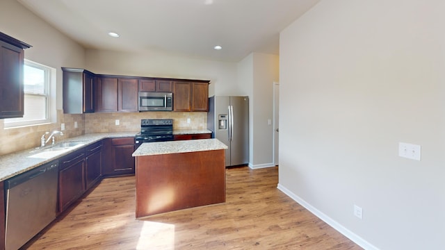 195 Sims Ct, Augusta, GA 30909 - kitchen with appliances with stainless steel finishes, a center island, backsplash, light wood finished floors, and recessed lighting