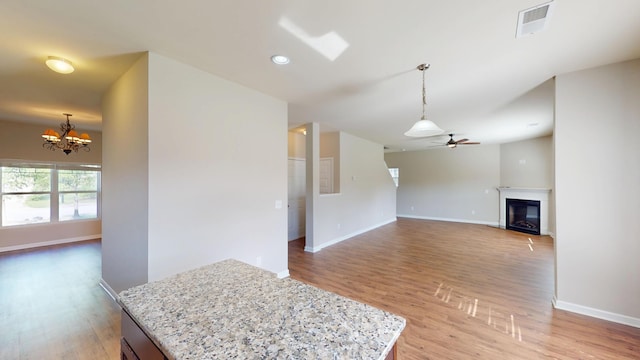 195 Sims Ct, Augusta, GA 30909 - unfurnished living room with light wood-style flooring, a chandelier, a ceiling fan, a glass covered fireplace, and recessed lighting