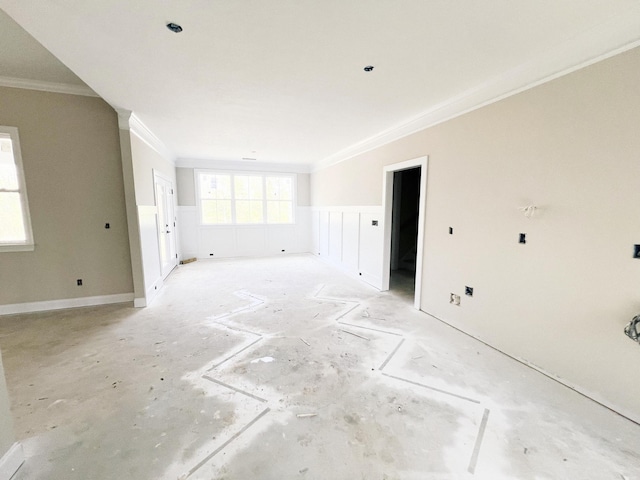 empty room with a wainscoted wall and ornamental molding