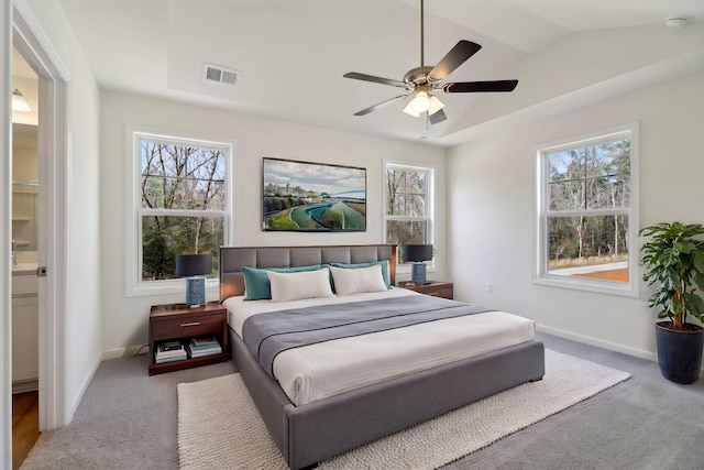 bedroom with carpet, baseboards, visible vents, a tray ceiling, and lofted ceiling