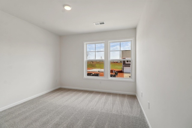 carpeted spare room featuring baseboards and visible vents