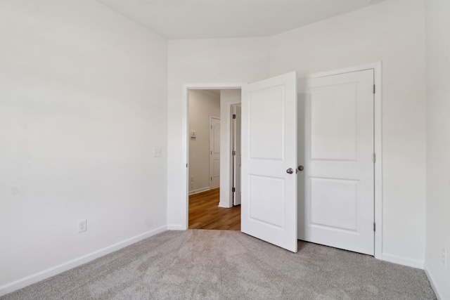 unfurnished bedroom featuring a closet, baseboards, and carpet