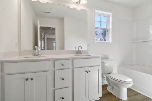 full bath featuring double vanity, visible vents, toilet, and a sink