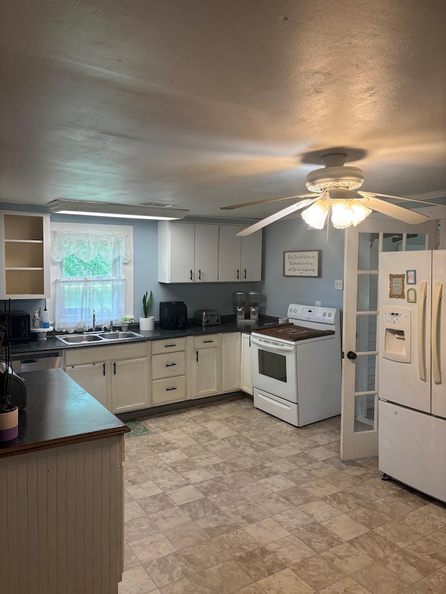 2023 Gamble School Rd, Stapleton, GA 30823 - kitchen with white appliances, a sink, dark countertops, a ceiling fan, and french doors