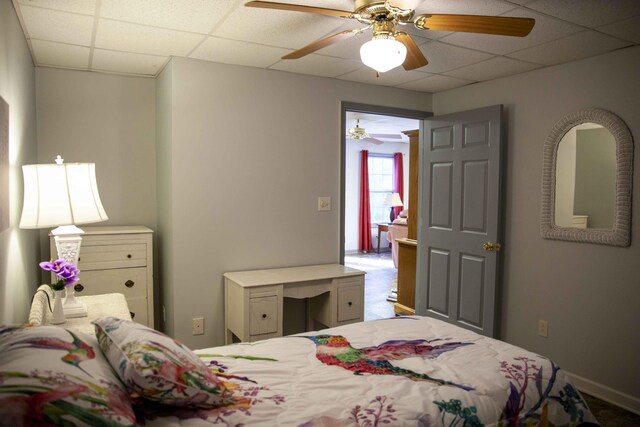 bedroom featuring a drop ceiling and ceiling fan