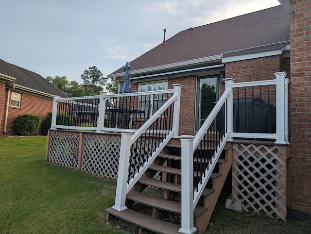 deck with a lawn and stairs