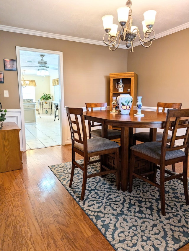 dining room featuring a chandelier, crown molding, and light wood finished floors