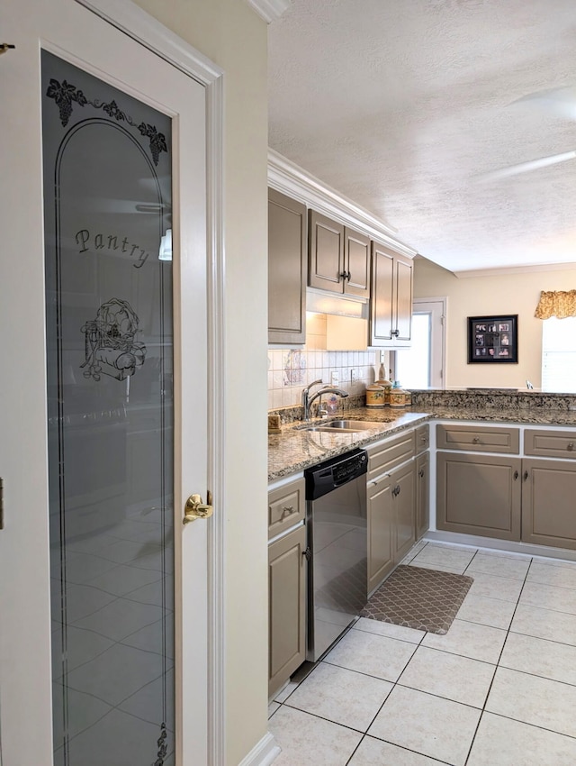 kitchen with dishwasher, a sink, a textured ceiling, light tile patterned floors, and stone counters