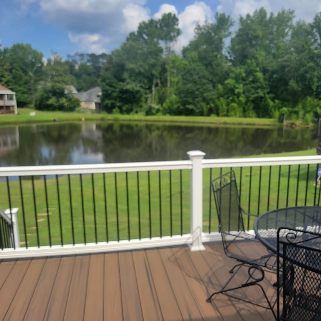 deck with a water view and a yard
