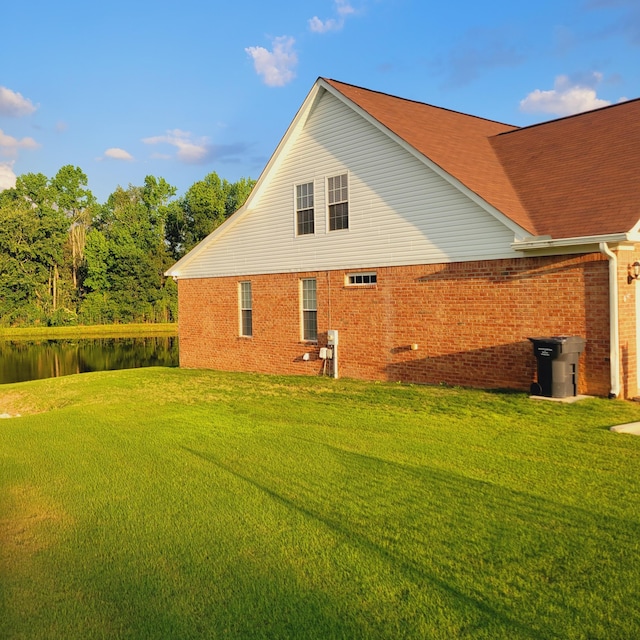 view of home's exterior featuring brick siding and a lawn