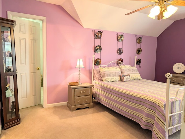 bedroom featuring vaulted ceiling, light carpet, baseboards, and a ceiling fan