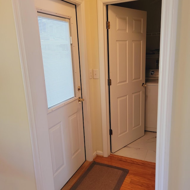doorway featuring baseboards and light wood-type flooring