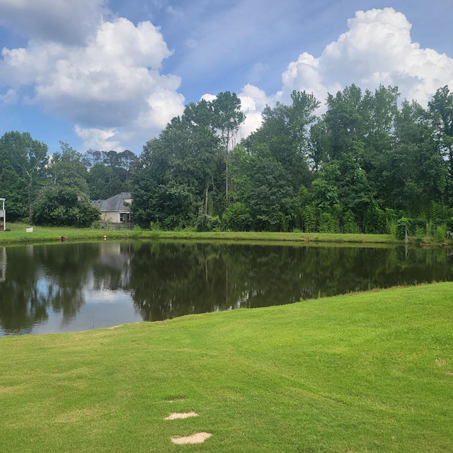 surrounding community with a water view and a lawn