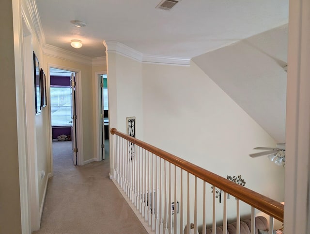 hall with light colored carpet, baseboards, and ornamental molding