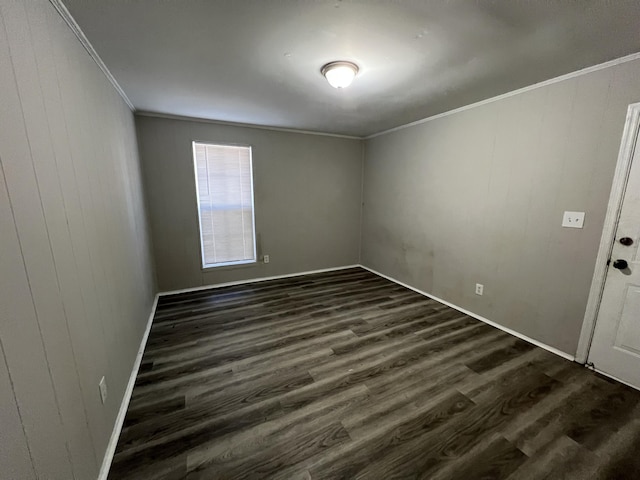 spare room featuring crown molding, dark hardwood / wood-style flooring, and wooden walls