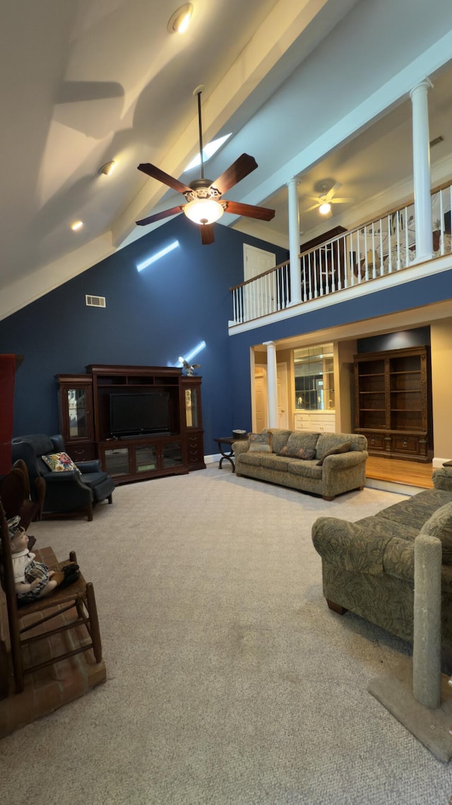 living room with ornate columns, ceiling fan, carpet floors, and vaulted ceiling with beams